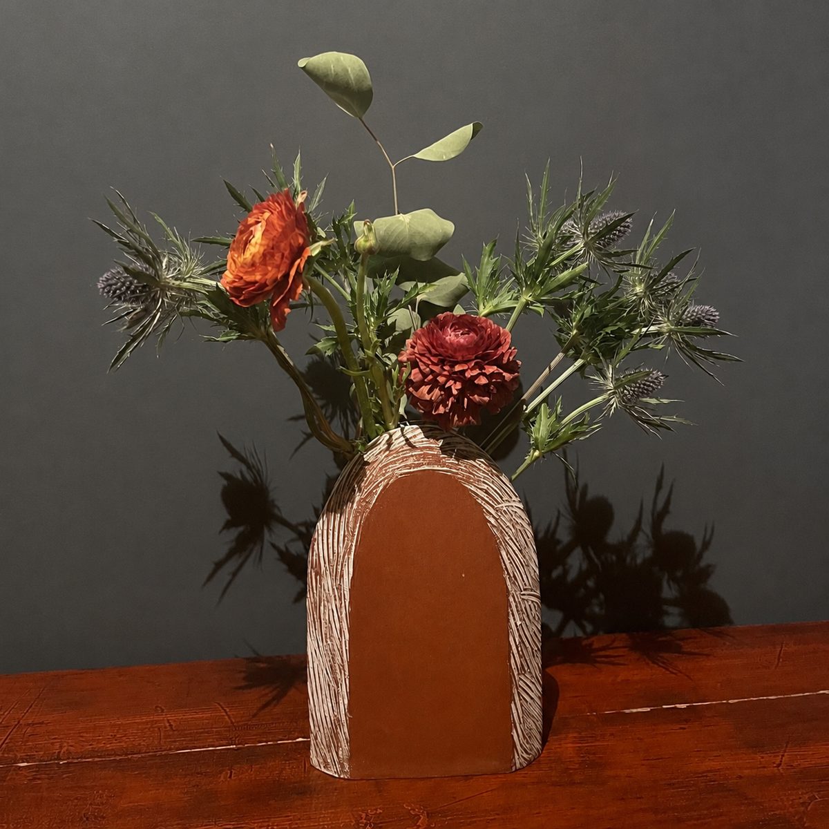 Ranunculus and thistle arrangement